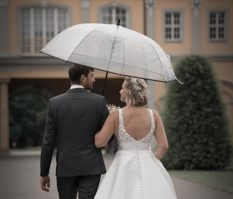 Hochzeitspaar in Gera im Küchengarten, laufen auf die Orangerie zu, mit Sonnenschirm in der Hand
